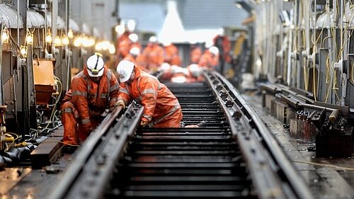 Men performing works on train tracks.